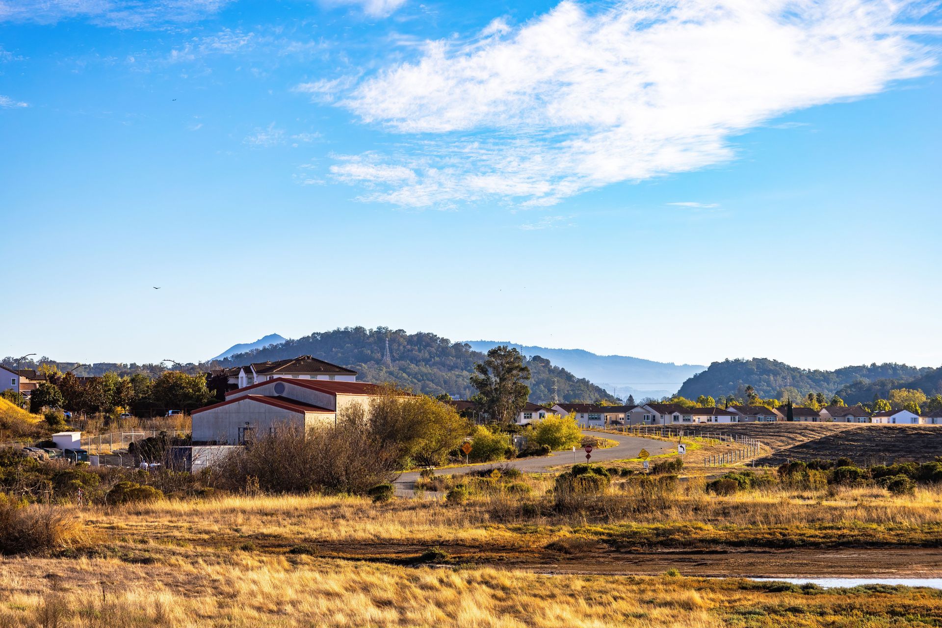 Beautiful rural landscape with houses and mountains under a blue sky.